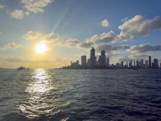 Naklejka premium Cartagena Colombia Skyline Silhouetted Against a Brilliant Golden Sunset Over the Caribbean Sea with High Rise Buildings and Tropical Coastal Atmosphere