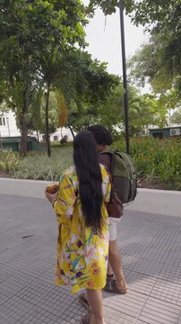 Romantic couple walking and kissing in a tropical park