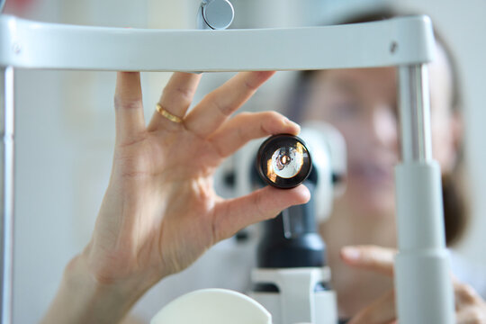 Ophthalmologist holds diagnostic lens during eye examination