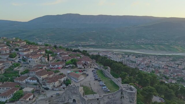 Aerial view of the historic Berat Castle walls and traditional stone houses in the old town at sunset in Berat, Berat County, Albania.
