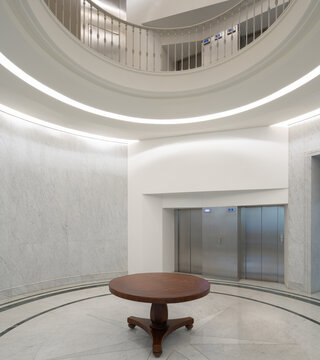 Neoclassical office lobby with elevator and circular balcony