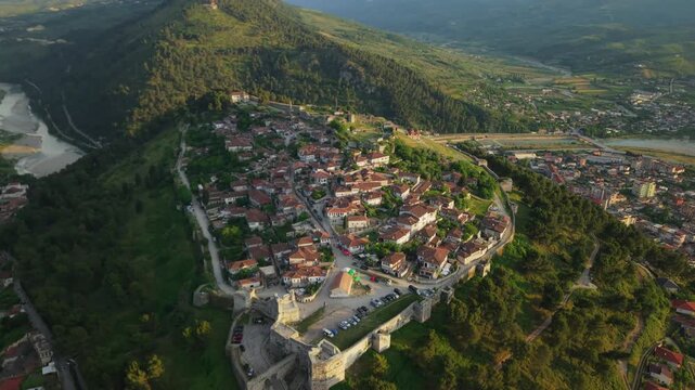 Aerial view of the historic Berat Castle and traditional stone houses with red-tiled roofs overlooking the Osum River in Berat, Berat County, Albania.