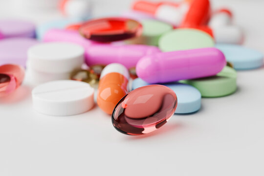 Close-up of colorful pills and capsules on white surface