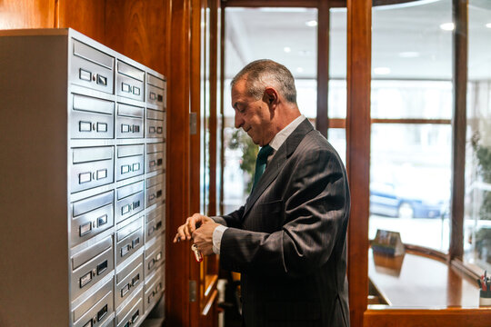 Old building caretaker check mailbox in residential lobby