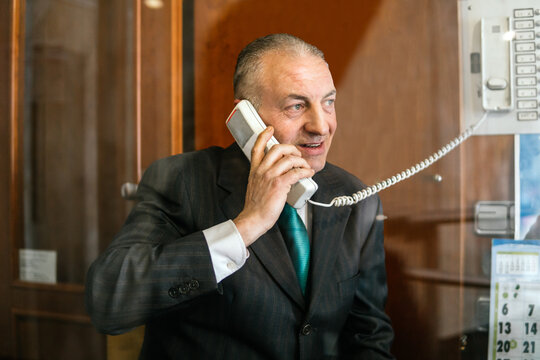 Caretaker use intercom telephone in old office building