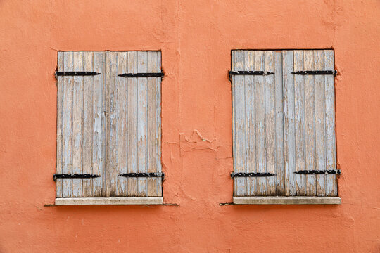 Vintage wooden window on a weathered plaster wall of an historic house