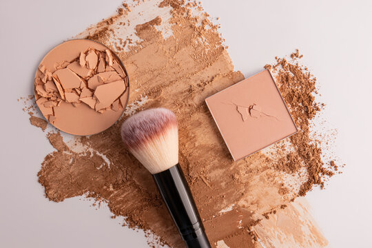 Broken compact powder with brush and cosmetic swatches