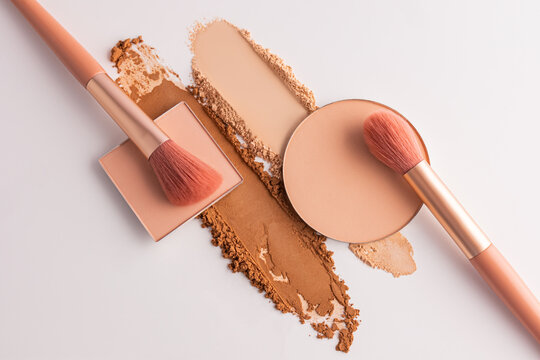 Peach compact powder with brush and makeup swatch