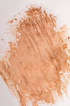Beige compact powder smear on white background