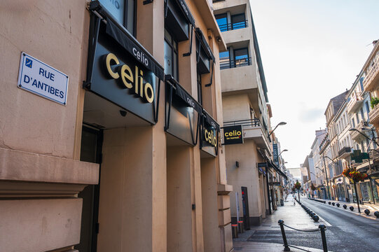 Cannes, France - August 02, 2026: A street scene features a Celio store with multiple signs and a "Rue d'Antibes" street sign