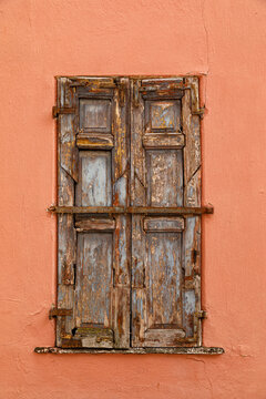 Vintage wooden window on a weathered plaster wall of an historic house