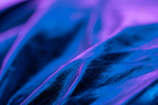 Abstract blue and purple fabric texture with neon light