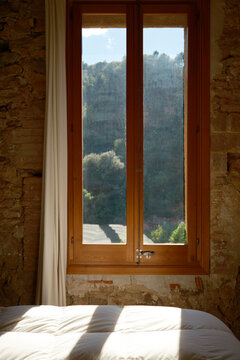Sunlit bedroom window overlooking Mura village countryside