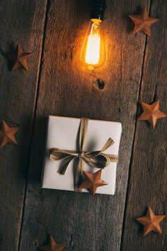 Rustic: Glowing Bulb Above Wrapped Christmas Present
