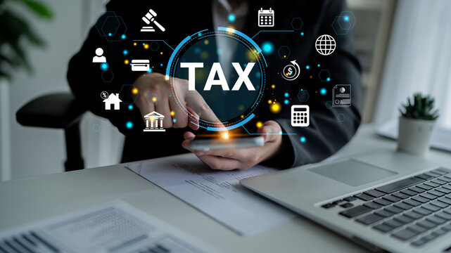 Hands of a businessperson using a smartphone with tax-related icons and symbols displayed around, emphasizing finance, planning, and accounting concepts Haptic.