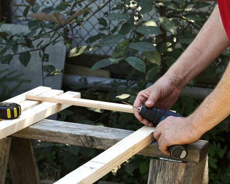 Woodworker drill timber frame during outdoor carpentry work