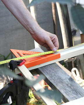 Woodworker measure timber with tape measure and square