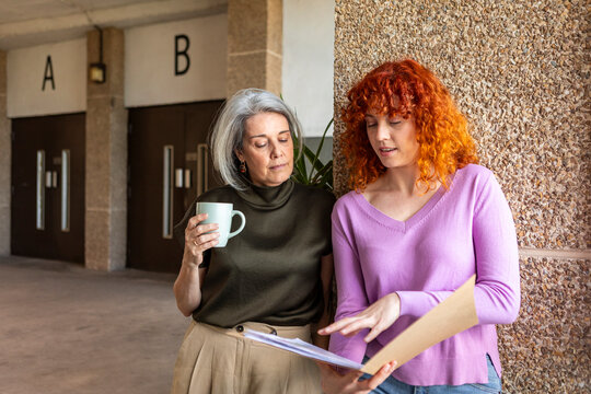 Two businesswomen reviewing documents during coffee break