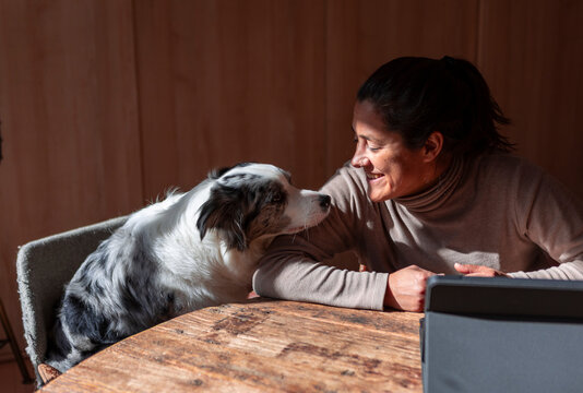 Woman bonding with her dog at a wooden table