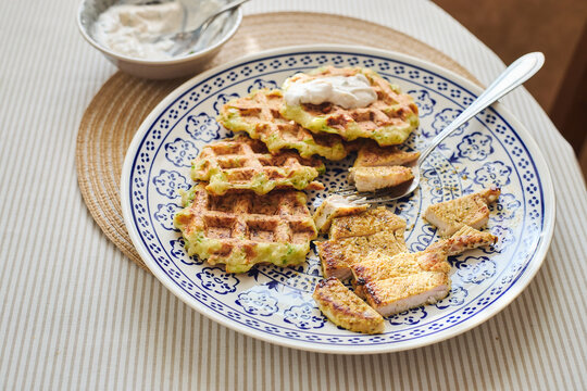 Zucchini waffles with roast turkey on patterned plate