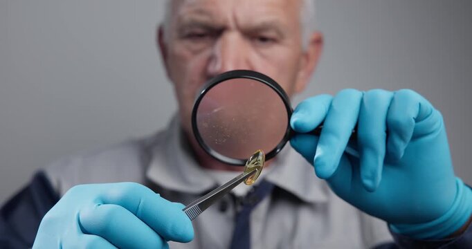 Elderly man inspecting capsule with magnifier in workspace, pharmacology factory with testing of quality product.