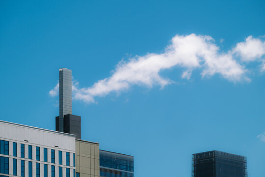 View of modern skyscrapers with a plume of steam rising against a clear blue sky in Philadelphia, Pennsylvania, United States.