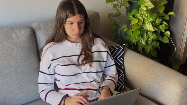 Beautiful businesswoman sitting on a sofa in her modern living room during a stressful day at work