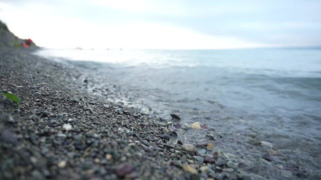 The coastal part of Lake Sevan with its mirror under clear water and beach view of the shore