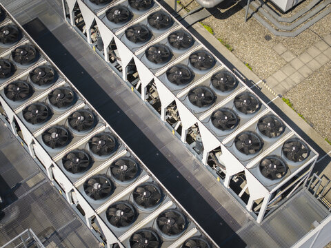 Aerial view of a large industrial cooling system with rows of fans on the roof of an ai data center in Poland.