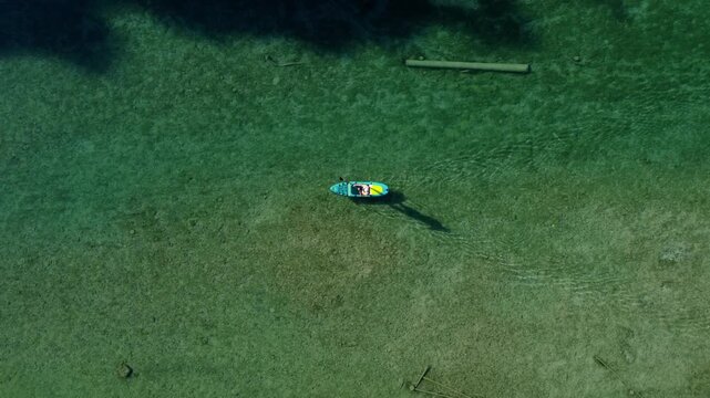 SUP Paddler on Crystal Clear Ager River near Attersee, Austria &ndash; Top Down Aerial Drone View