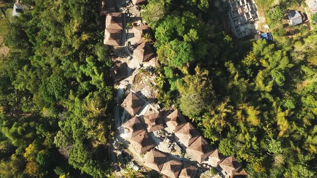 Aerial view of the traditional thatched-roof houses of Kampung Prai Ijing nestled in lush tropical greenery in Kota Walkabubak, East Nusa Tenggara, Indonesia.