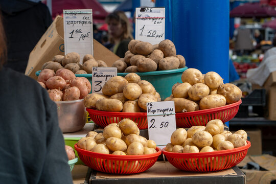 Photo showing fresh potatoes on a stand at a farmers market. Raw potatoes on the shelf in grocery store