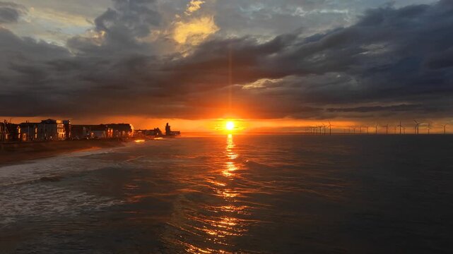 ​Aerial View of Sunset Scenic Coastline, Ocean Waves, and Wind Power Energy Farm