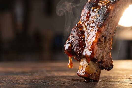 Smoked pork ribs glazed with barbecue sauce on rustic table