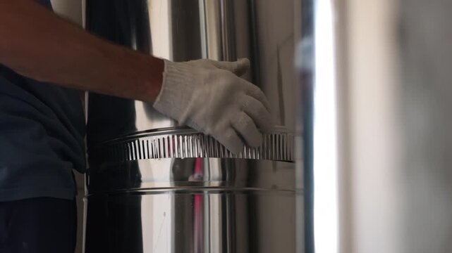 Worker connecting stainless steel ventilation duct sections