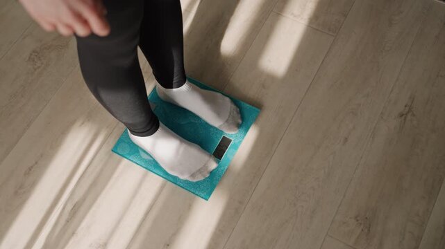 Assessing body weight under bright sunlight conditions. Standing on foot scale in sunlight for health evaluation. Measuring body weight with foot scale in direct sunlight during health check