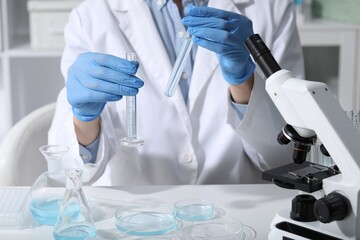 Fototapeta premium Scientist with test tubes in laboratory, closeup