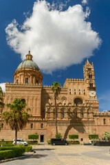 Fototapeta premium Frente de la Catedral de Palermo, en Sicilia. Se observa una torre, el reloj y la cúpula bajo una nube espectacular. Viajando por Italia y el mar Mediterráneo.