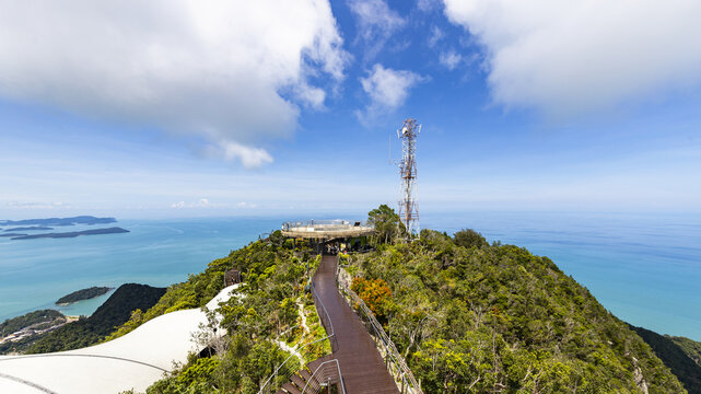 View of Langkawi Sky Bridge observation deck surrounded by lush tropical forest and overlooking the turquoise Andaman Sea under a bright blue sky Langkawi, Kedah, Malaysia.