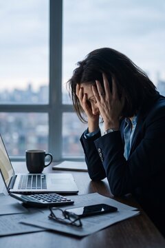 Exhausted Businesswoman Holding Head in Hands During Night Work Overtime