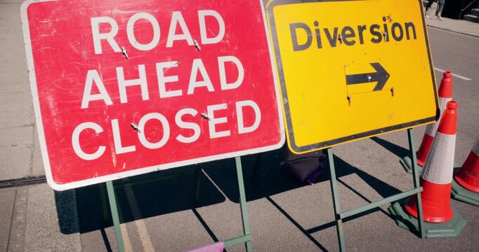 Road closed street sign &ndash; Emergency services diverted traffic highway road sign in the event of a roadblock. Travel safety on street diversion. High visibility red signage marking temporary closure.