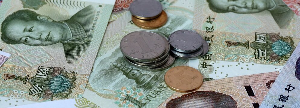 Chinese yuan money banknotes and coins on table. China cash bills of CNY currency