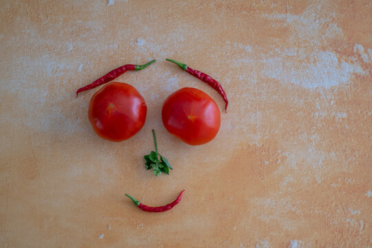 Funny face made from tomatoes, chilli peppers and basil