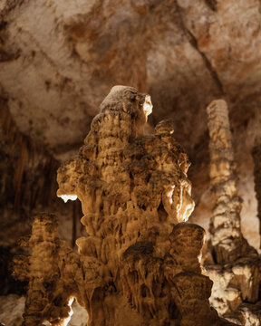 View of the intricate limestone stalagmites and rock formations inside the illuminated Postojna Cave in Postojna, Postojna, Slovenia.