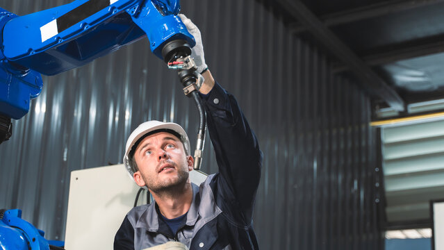 Factory Technician verifying machine setup During Routine Inspection of Automated Robotic Equipment During Overhead Robot Inspection Scene 142