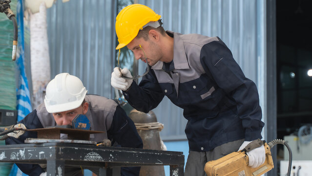 Professional factory technician reviewing machine controls During Robotic Equipment Maintenance in a Modern Manufacturing Plant