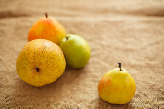 Fresh ripe organic pears on rustic burlap background with copy space