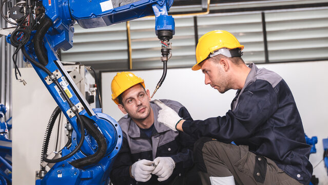 Engineering Professionals reviewing technical information Around an Industrial Robot During Maintenance and Quality Inspection Scene 258