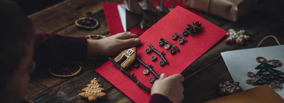 Banner. Family time, leisure activity, hobby, holiday recreation with kids. Process creation of handmade Christmas postcard with wooden sticks, buttons on craft recycled paper. Zero waste, diy gift