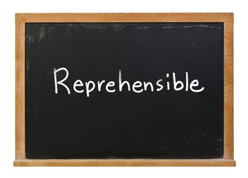 Reprehensible written in white chalk on a black chalkboard isolated in a wooden frame on white